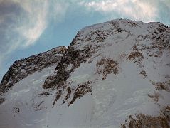 
Close up of the Broad Peak Central Summit and the Broad Peak Main Summit just after sunrise from Concordia.
The first ascent of Broad Peak was completed by Marcus Schmuck, Fritz Wintersteller, Kurt Diemberger, and Hermann Buhl on June 9, 1957. This extremely small expedition marked a major step forward in the development of Himalayan climbing. Diemberger: [Buhl's] plan was that from base camp onwards there would only be climbers on the mountain; they would do everything, load-carrying, establishment of camps and, finally, the assault on the summit. And it was all to be done without the use of oxygen. Diemberger reached the summit just as Marcus Schmuck and Fritz Wintersteller started their descent. As Diemberger was descending from the summit he met Buhl still ascending. Slowly, with all that incredible strength of his will, he started to move, very slowly, upwards. ... Two men were standing on a peak, still breathing heavily from the ascent, their limbs weary - but they did not notice it; for the all-enveloping glory of the sun's low light had encompassed them too. Deeper and deeper grew the colours. ... No dream-picture, this. It was real enough, and it happened on the 26,404-foot summit of Broad Peak.  Summits And Secrets by Kurt Diemberger.
